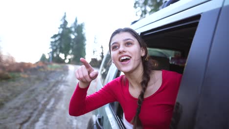 mujer feliz mirando por la ventana del coche