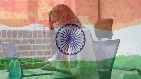 composition of woman wearing face mask in office over indian flag