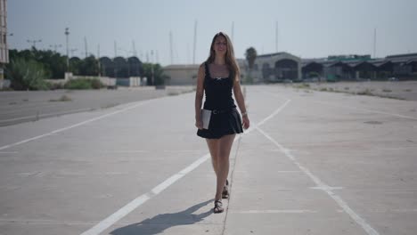 woman walking with tablet in urban setting