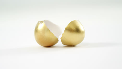 broken golden easter egg on white background