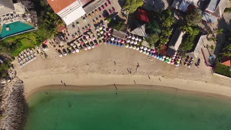 Aerial-view-of-Santa-Cruz-Bay-Beach,-showcasing-people-enjoying-various-activities