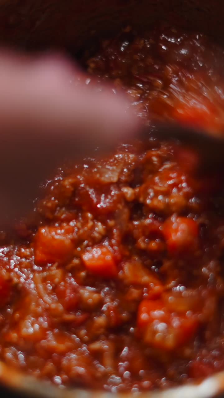 Close-up of Bolognese sauce being stirred