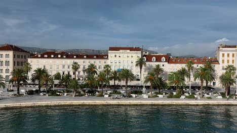 palm trees on the seaside promenade of split city - aerial track