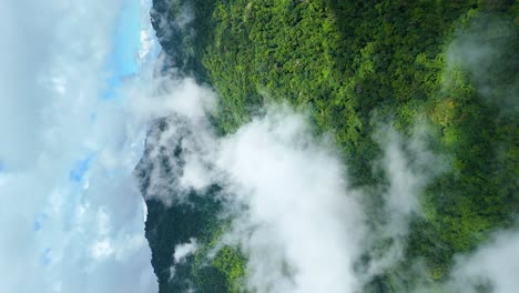 moving clouds with evergreen forest and beautiful mountain range landscape with clear blue sky, national park northern thailand, aerial drone, true vertical 4k video for social media 9:16 portrait