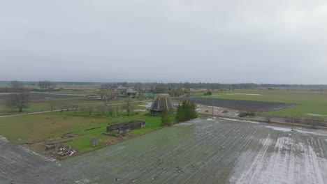 Hermosa-Vista-Aérea-Del-Antiguo-Molino-De-Viento-De-Madera-En-El-Medio-Del-Campo,-Molino-De-Viento-Prenclavu,-Día-De-Invierno-Nublado,-Amplio-Tiro-De-Drones-Avanzando