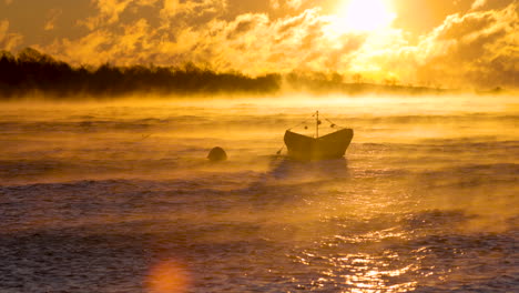 wind and golden steam whip across an anchored rowboat during a freezing subzero sunrise