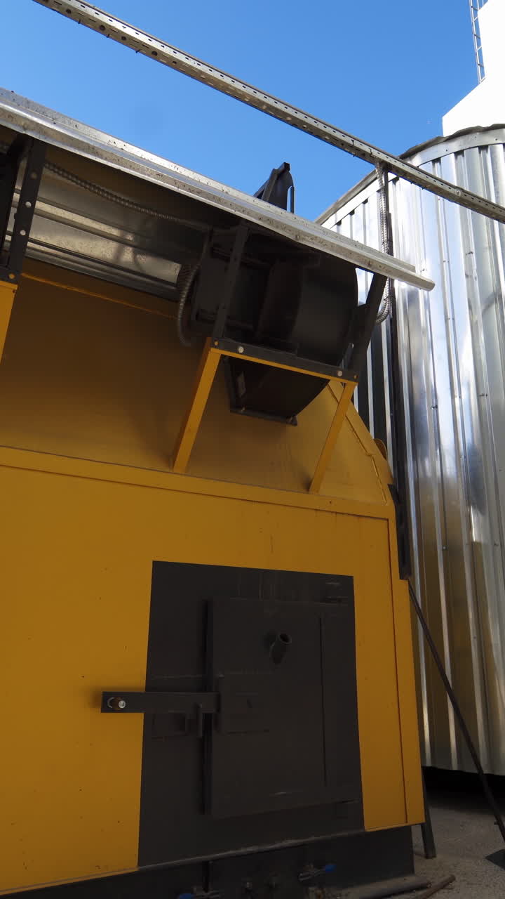 Industry outdoors. Small industrial building on a factory. Exterior of modern grain processing plant at sunny daytime. Vertical video