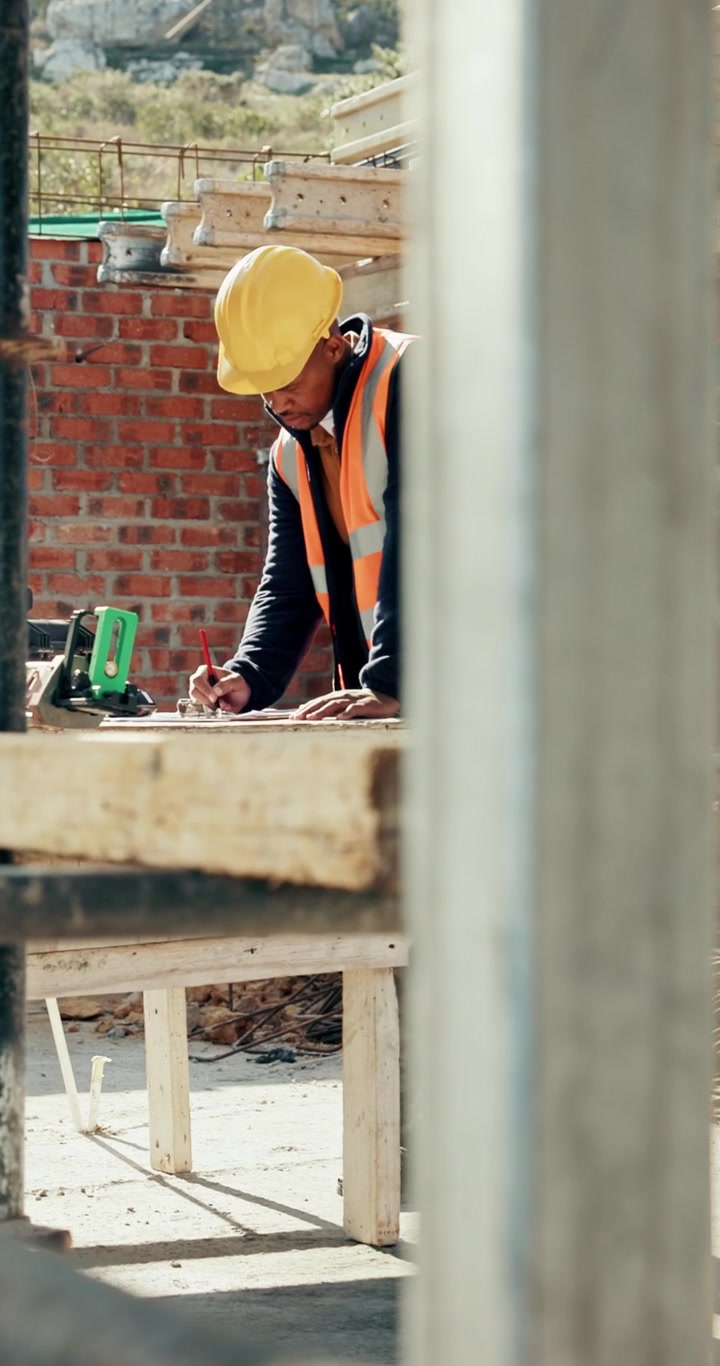 Construction Worker Using Walkie Talkie and Reviewing Blueprints on Site