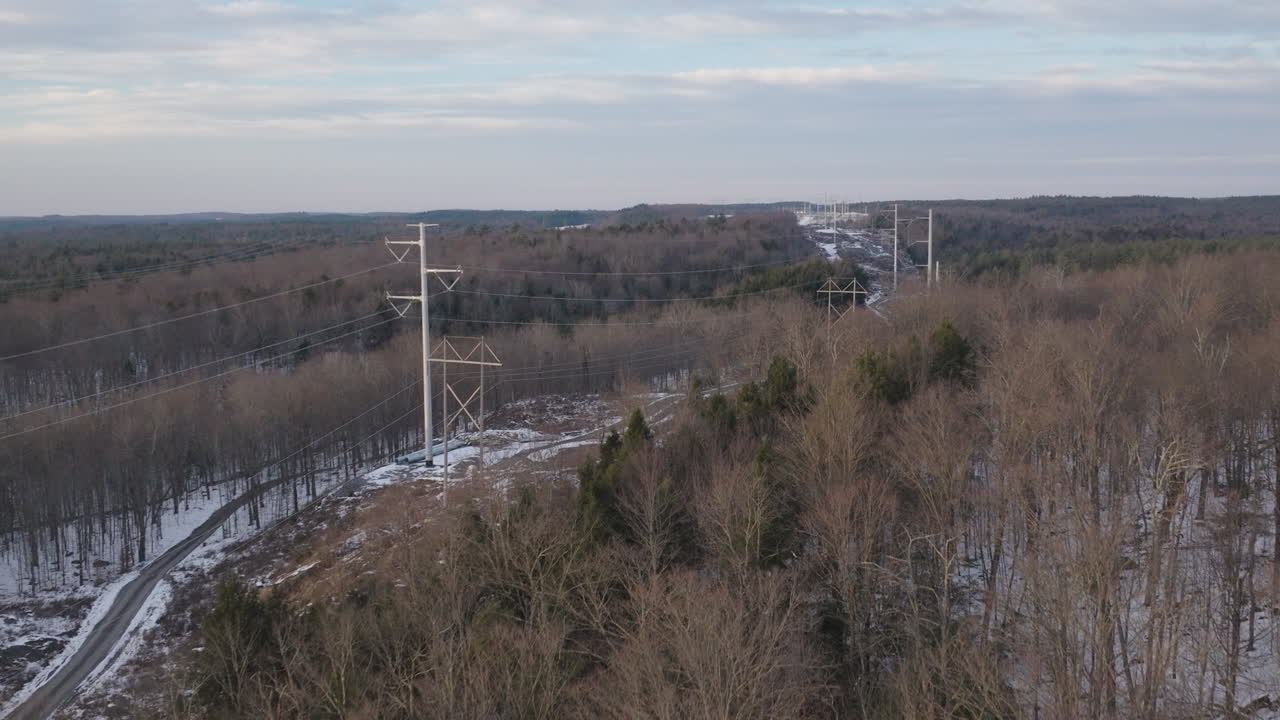 vista aérea de líneas eléctricas en un paisaje forestal nevado