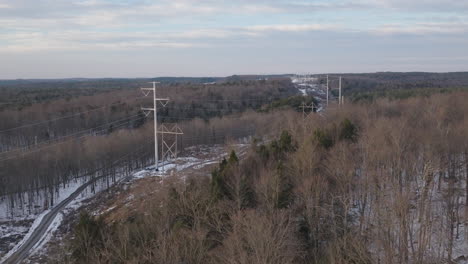 aerial view of electrical power lines in snowy forest landscape