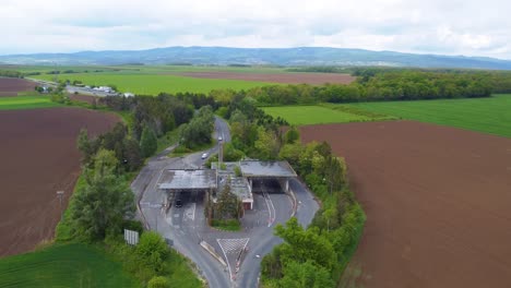 Old-Border-Crossing-in-Hataratkelo-at-the-Border-of-Austria-and-Bucsu,-Hungary-With-Crops-and-Mountains-in-the-Background