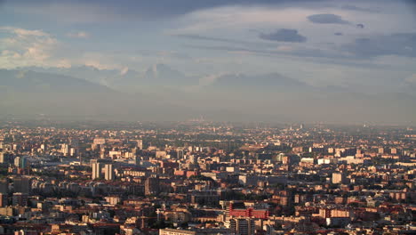 massive alps and milan city bellow during sunset, aerial view