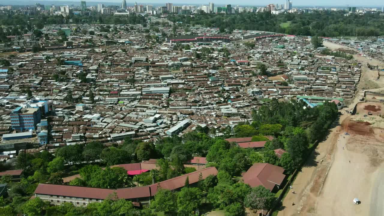 vista aérea del gran distrito de tugurios de kibera y la ciudad desarrollada de nairobi en el fondo