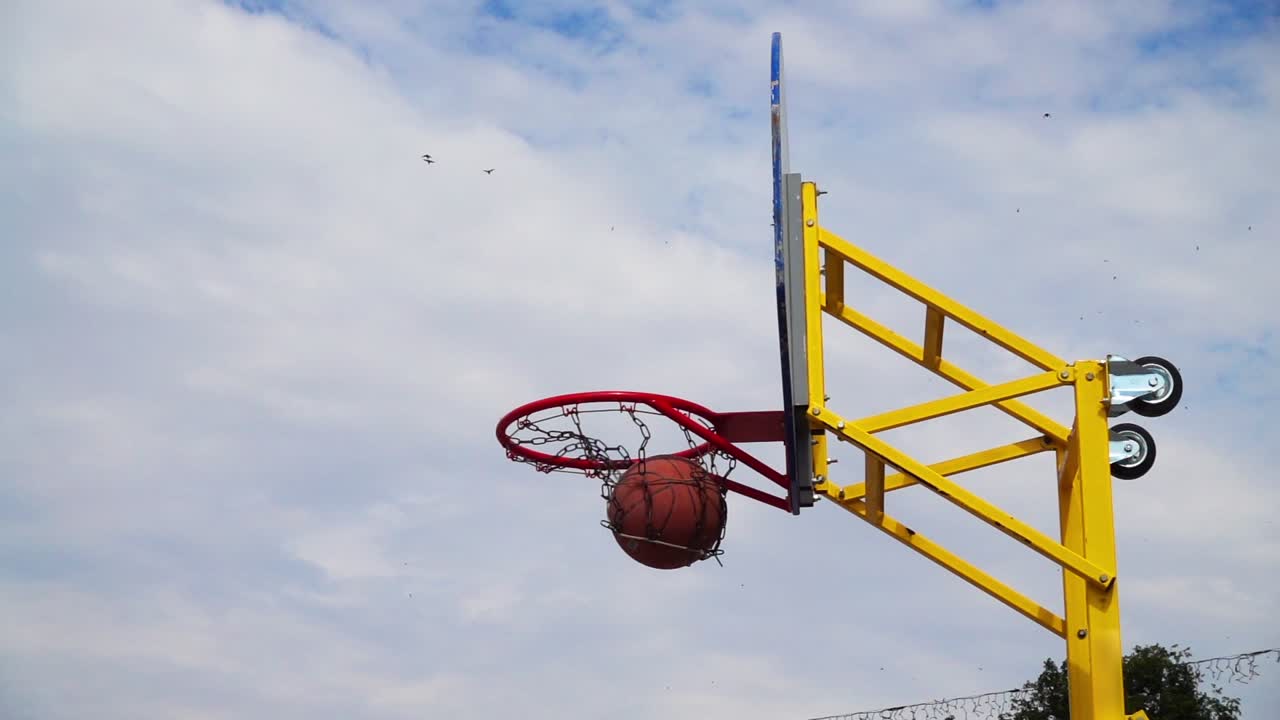 Pallacanestro da strada. La palla vola verso il canestro. Al rallentatore