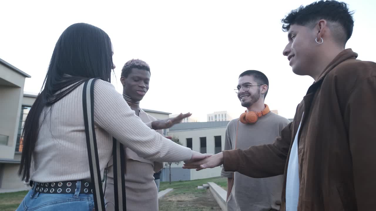 Smiling multiethnic group of friends join hands to support each other