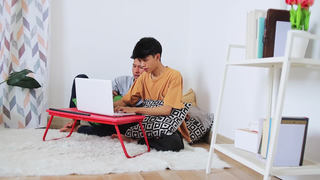 Two brothers engrossed in mobile games sharing casual moment together on cozy rug