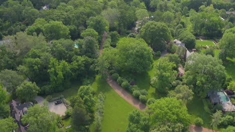 Overhead-view-of-beautiful-yards-and-homes-in-upscale-neighborhood-with-tilt-up-to-the-skyline-on-the-horizon