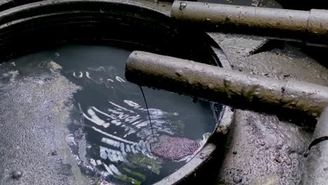 aguas residuales químicas negras que salen de la tubería al tanque de almacenamiento de procesos industriales