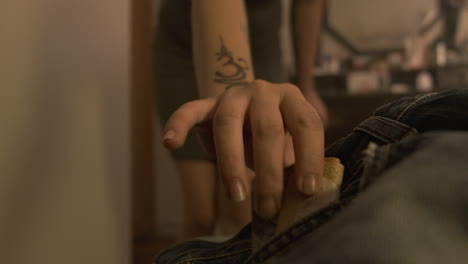 close up of woman taking money from pants pocket