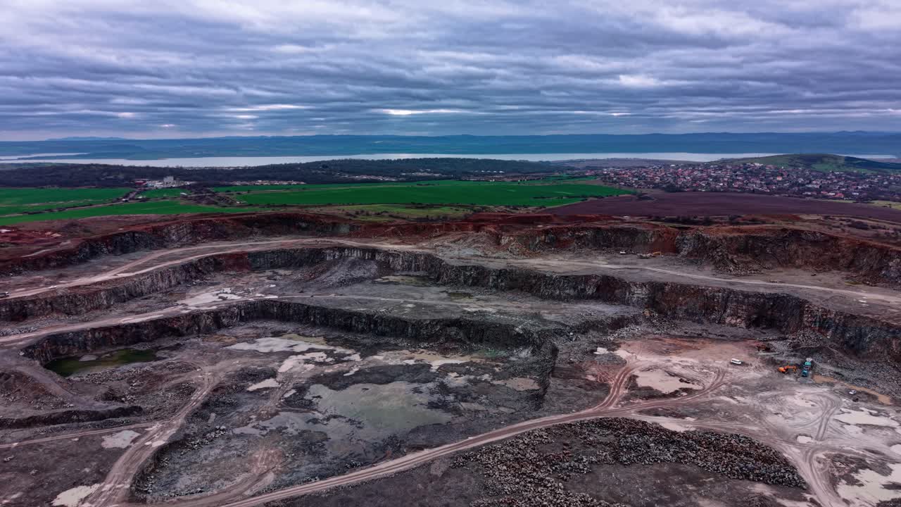 Granite quarry in an industrial area with machines and clouds above