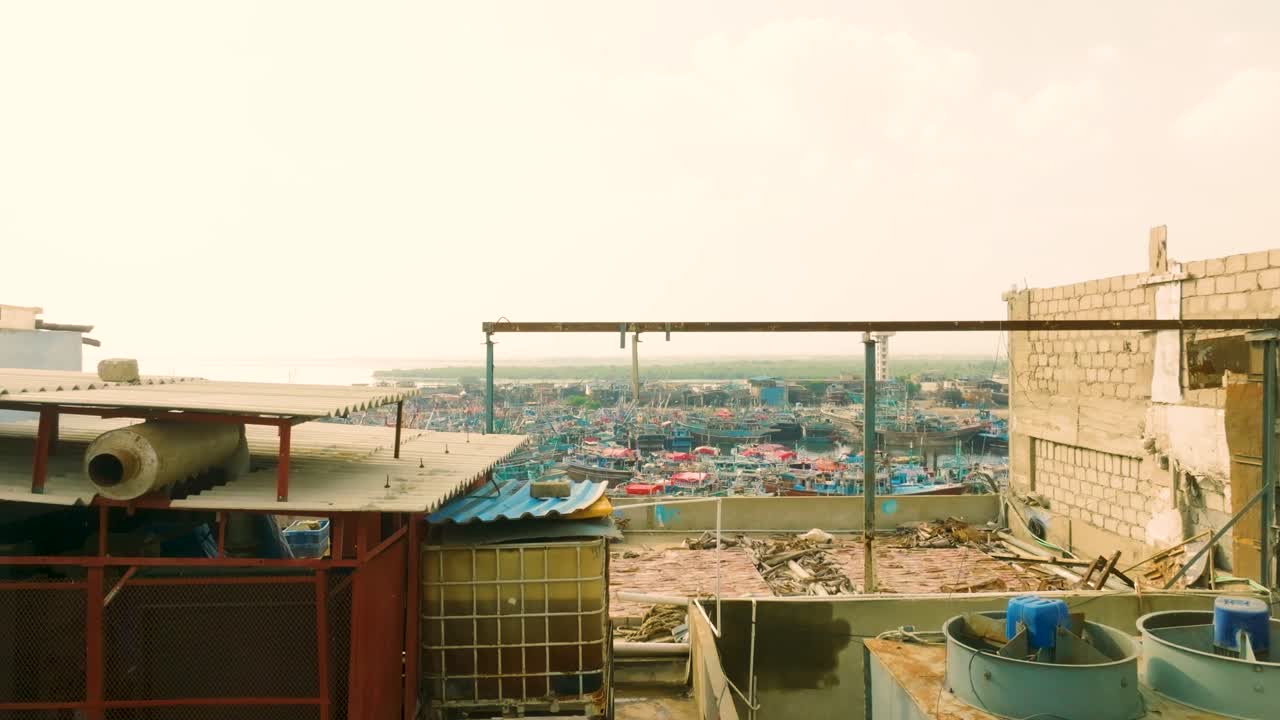 Busy Karachi Fisheries harbor featuring many traditional fishing boats and coastal cityscape