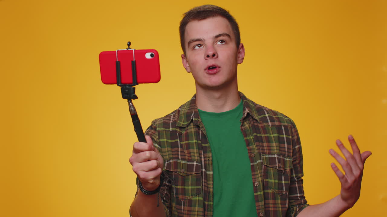 L'uomo del blogger si fa un selfie sul cellulare, si fa una selfie stick, comunica in video con gli abbonati.