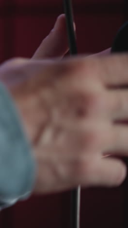 un primer plano de la mano de un hombre con una manga azul agarrando un soporte de micrófono, con un enfoque en la textura detallada de la piel y la tela