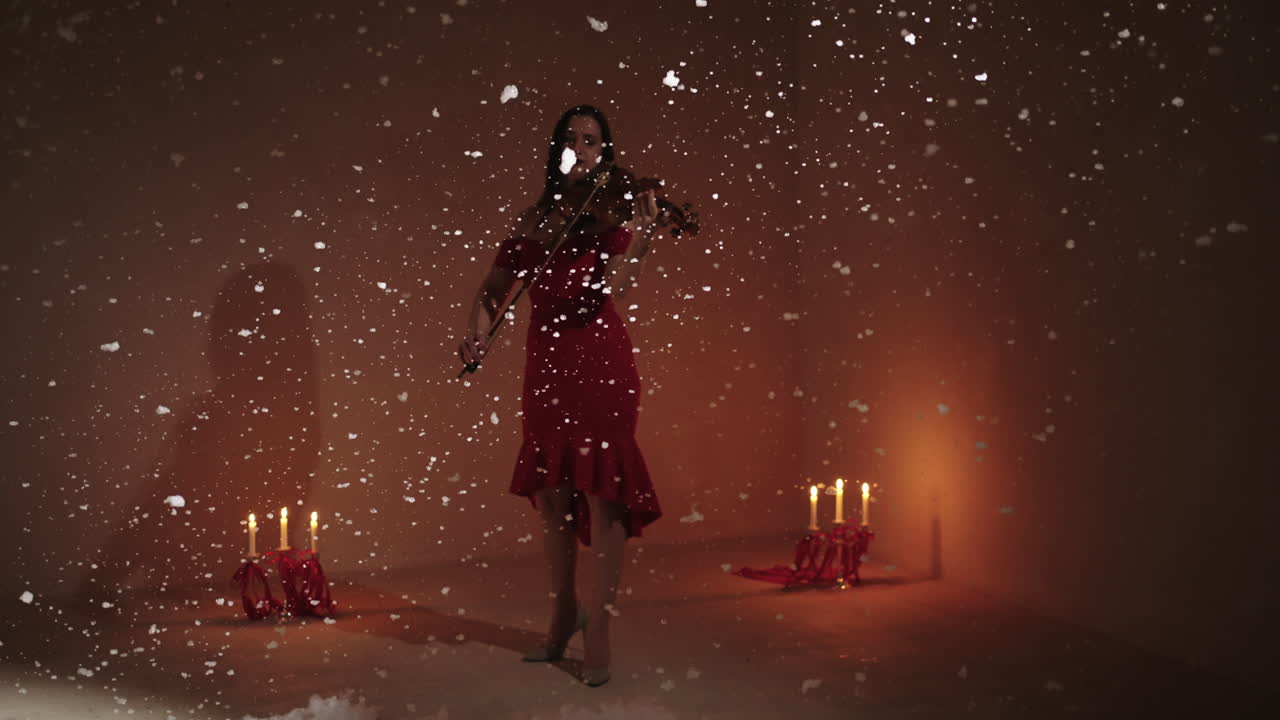 женщина в красном платье играет на скрипке в снежной обстановке