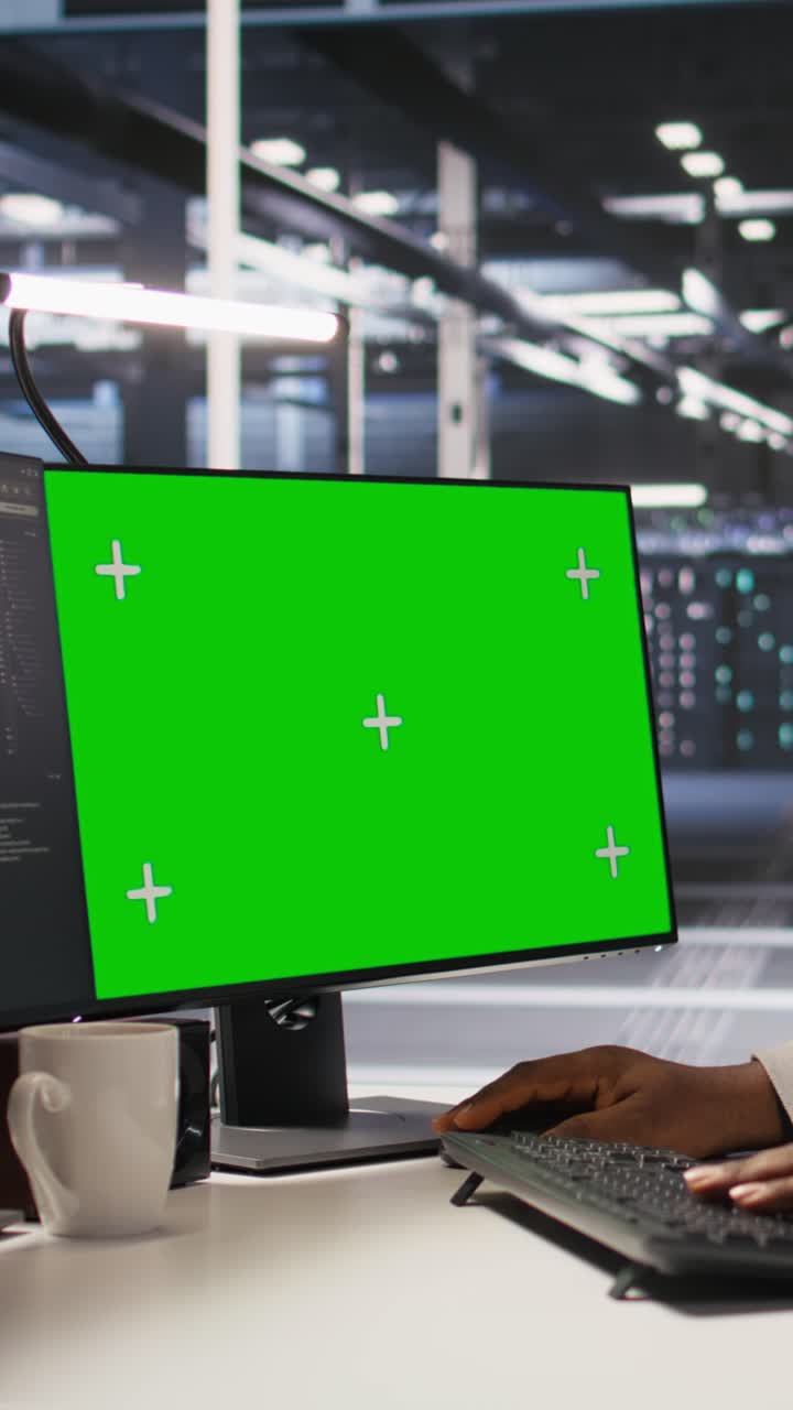 Vertical video Data center programmer working on green screen desktop PC