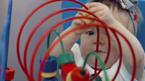 child plays with a multi-colored toy 25