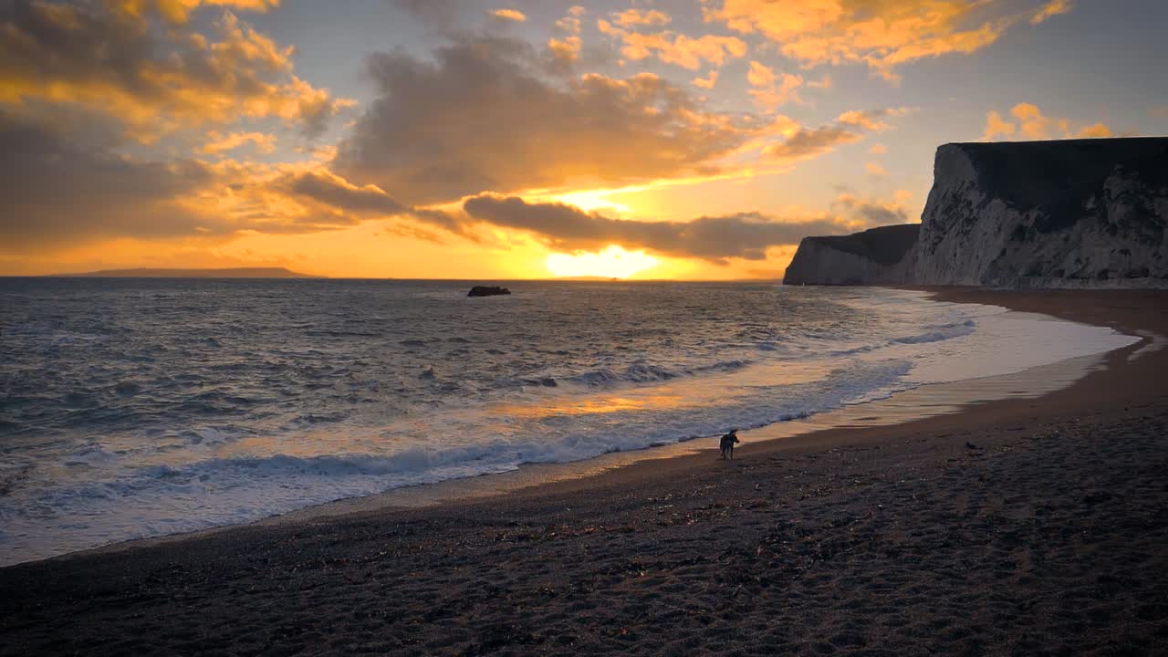 Spiaggia di Durdle Door sulla Costa Giurassica vicino a Lulworth nel Dorset, Inghilterra, con un cielo colorato e suggestivo.