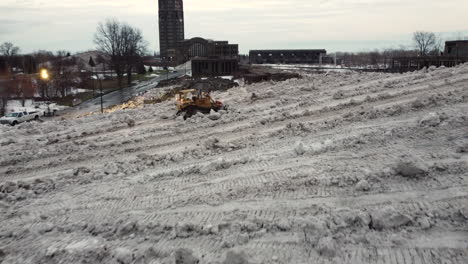 Ein-Bulldozer,-Der-Den-Schnee-Auf-Der-Schneedeponie-Aufhäuft