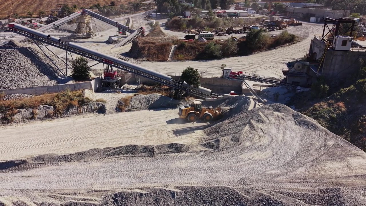 Construction site with machinery moving gravel and stone