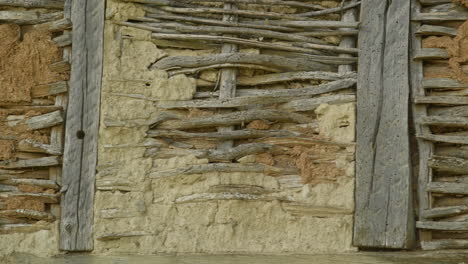 old wattle and daub timber framed barn of mud and sticks wall texture pan shot