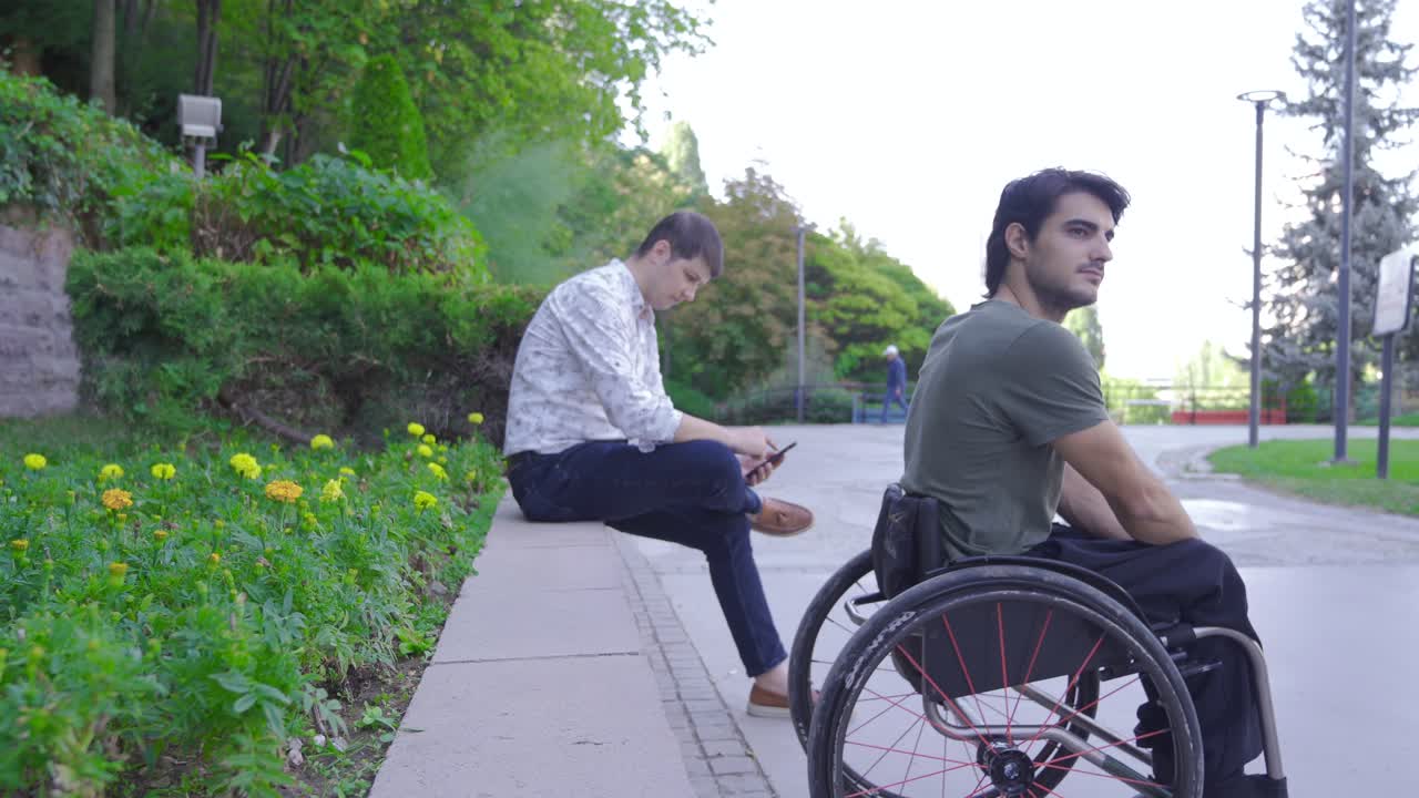 el adolescente sentado en una silla de ruedas está aburrido.