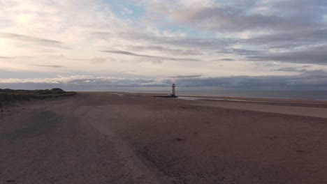 vuelo aéreo lento y paso del faro abandonado en una playa del norte de gales