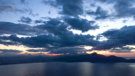 lapso de tiempo de drones del paisaje rural con montañas y océano, nubes en movimiento rápido al atardecer