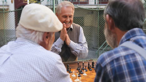 Anciano-Felizmente-Haciendo-Un-Movimiento-De-Ajedrez-Y-Siendo-Alegre-Por-Tener-Un-Juego-Exitoso