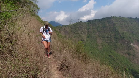 Female-Hispanic-hiker-walks-carefully-on-rim-edge-of-volcano-caldera