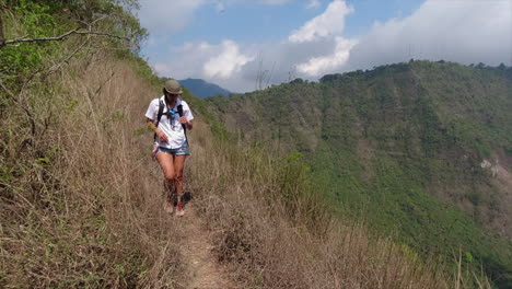 female hispanic hiker walks carefully on rim edge of volcano caldera