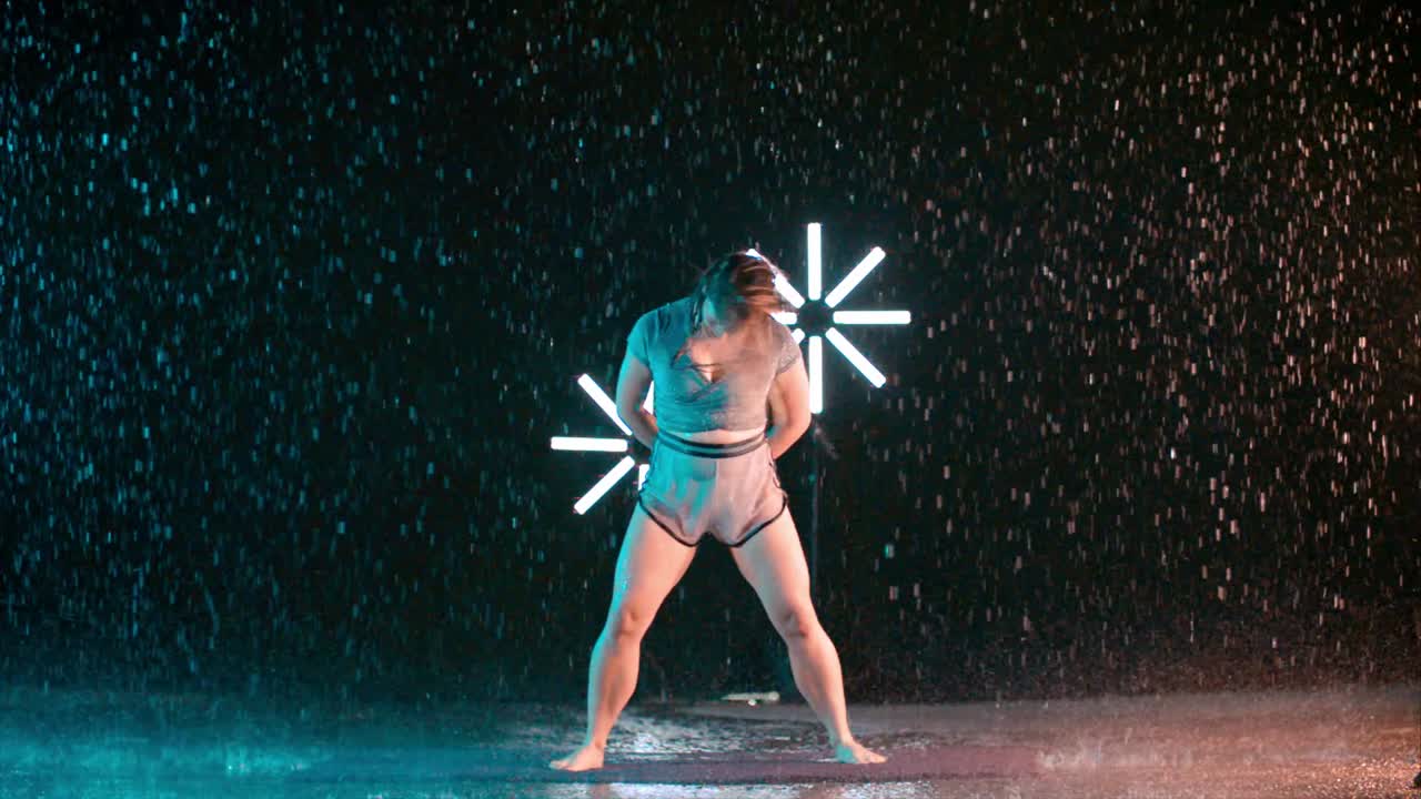 Female dancer spinning hair in the rain, super slow motion effect