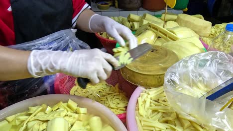 person slicing bamboo shoots for fermentation