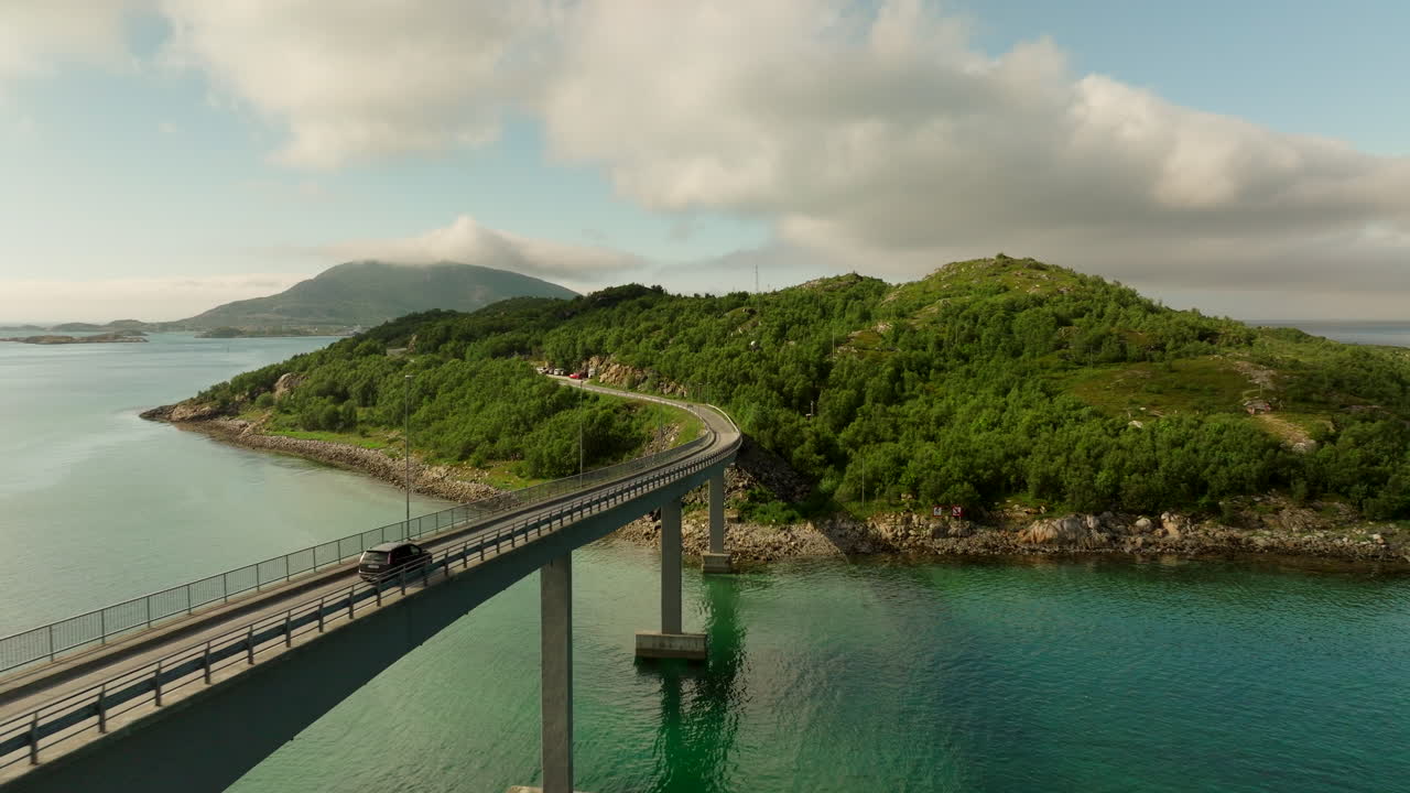 Car drives over bridge on road trip toward Sommaroya summer island, aerial view