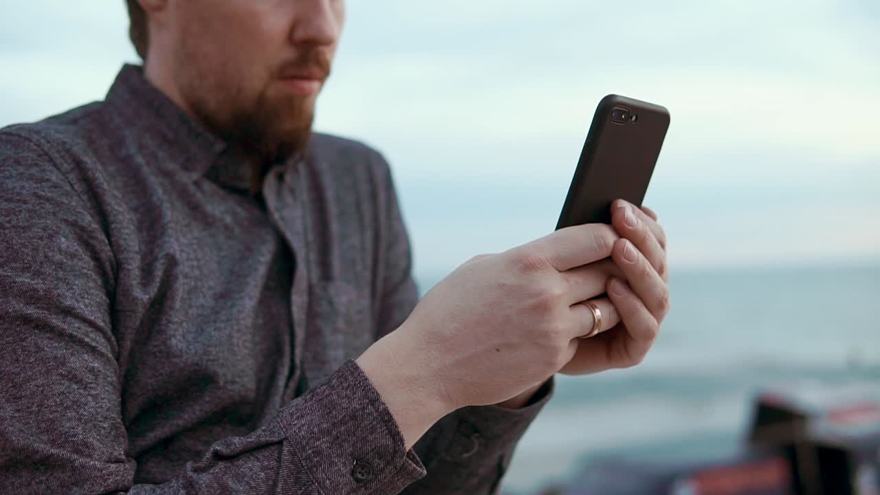 바다 에서 스마트폰을 사용하는 남자