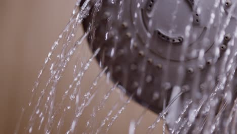 agua que fluye del cabezal de la ducha en el baño, primer plano