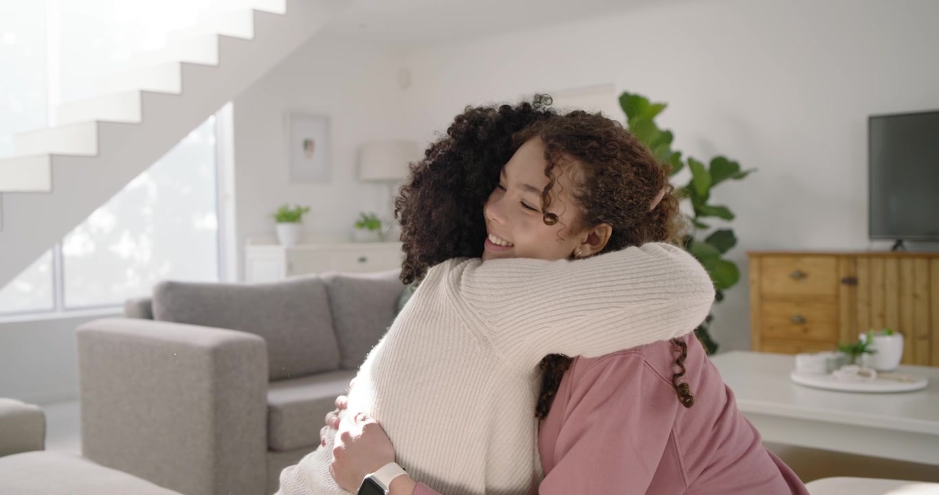 Famiglia afroamericana, donna adulta che entra abbracciando un giovane e salutando a casa mentre un anziano tiene in mano una tazza