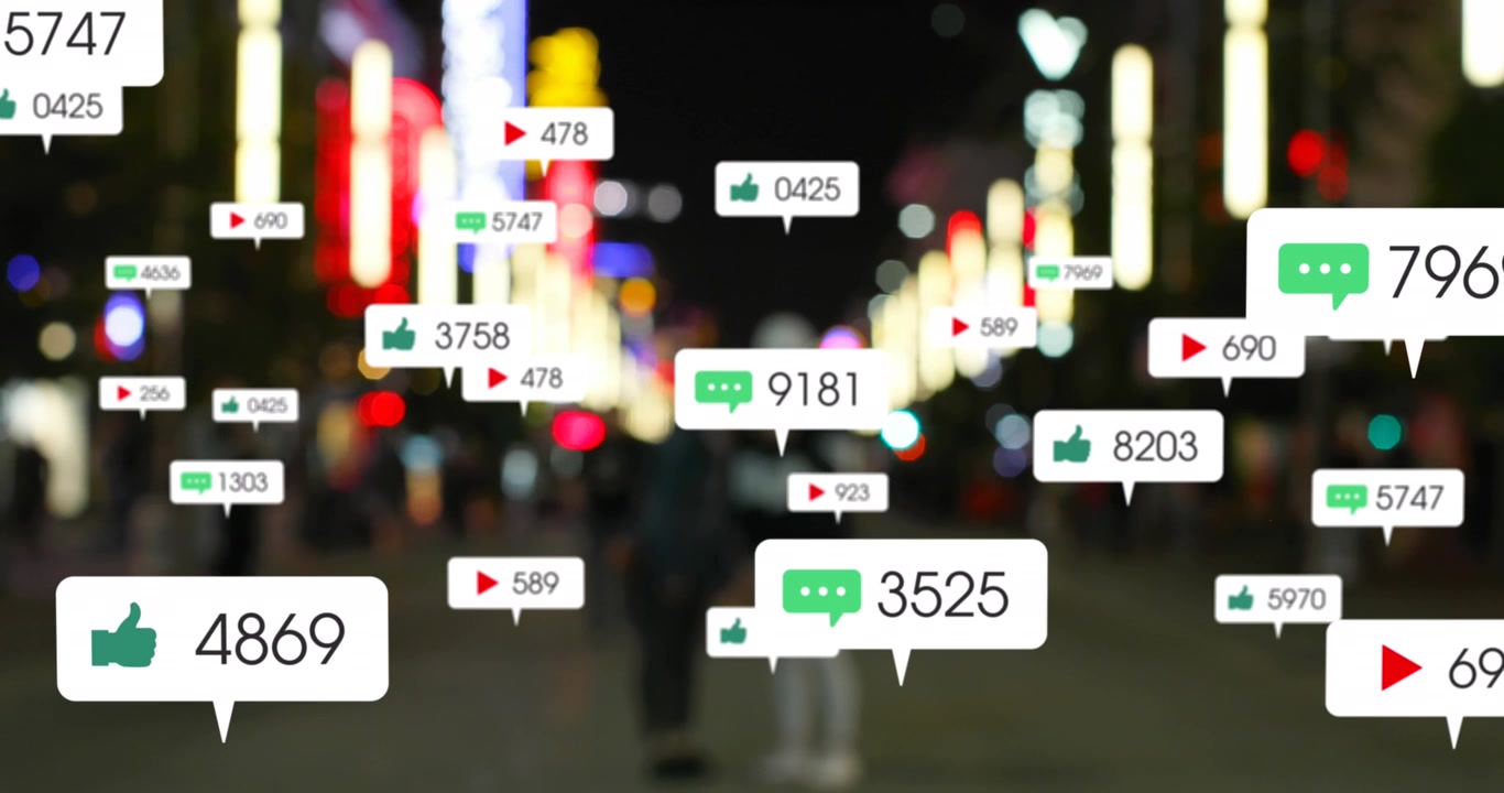 Animation of social media icons floating over blurred view of people walking on the street at night