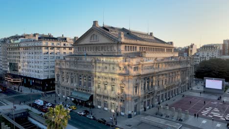 the famous colon theater of buenos aires, rear entrance view of iconic opera house at 9 de julio avenue, aerial panning shot capturing the exterior details of eclectic architectural building