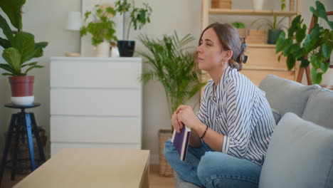 smiling woman lost in daydreams with book