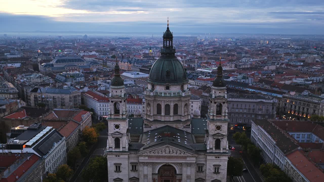 Primo piano aereo della maestosa cupola e delle torri gemelle della Basilica di Santo Stefano che si ergono fiere sul centro di Budapest